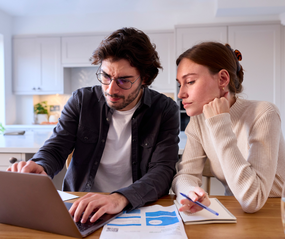 Worried couple at home struggling to organise travel health 