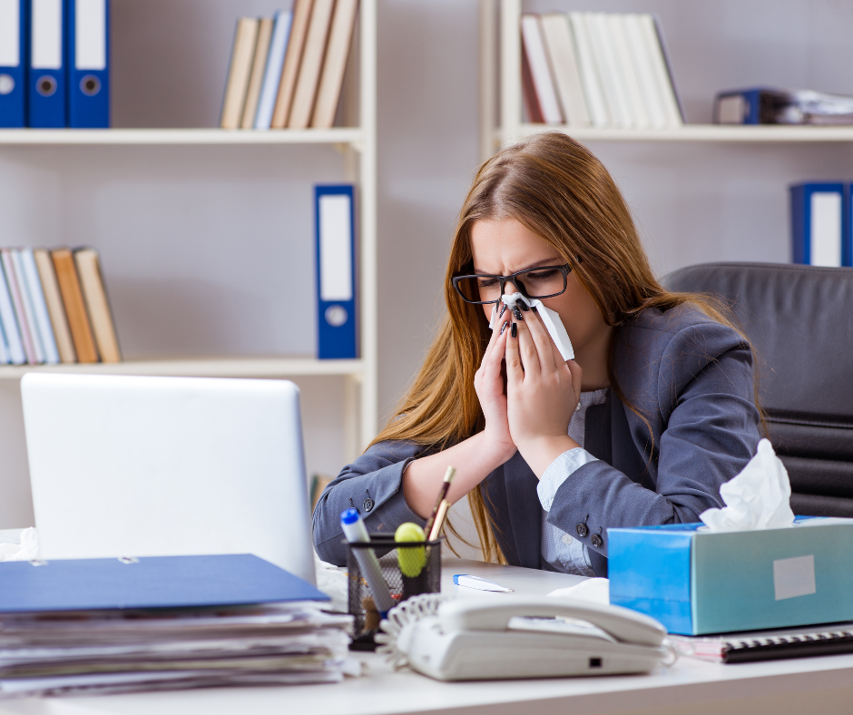 Sick employee sneezing in the office